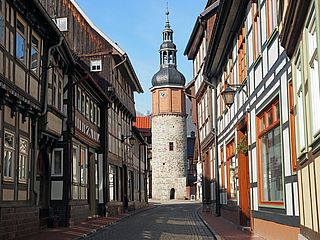 Eine Straße mit Fachwerkhäusern und einem Turm im Harz.