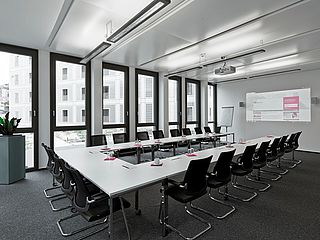 Der Raum des ecos office centers in Stuttgart verfügt über eine große Leinwand für Präsentationen während des Meetings