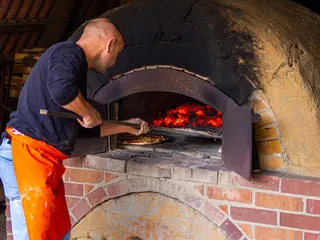 Gemeinsam als Gruppe beim Kochevent Pizza im Feldbackofen des Gut Karlshöhe in Hamburg backen macht Spaß und verbindet