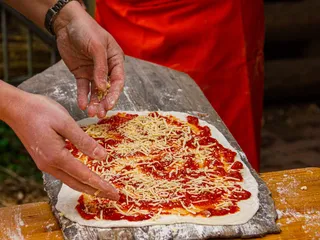 Pizzateig selber herstellen, belegen und dann im Feldbackofen backen - ein tolles Teamevent beim Gut Karlshöhe in Hamburg