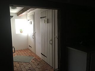 Weiße Holztüren schließen an den ländlichen Vintage-Stil der Diele am See im Herzogtum Lauenburg an