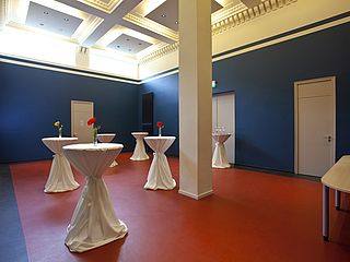 Das Foyer, der Blaue Salon, erstrahlt in dunkelblauen Wänden und karminroten Boden
