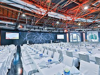Schlichte Tischdekoration und parallele Tischreihen im Eventbereich der Lokhalle Mainz schaffen Raum für viele Gäste