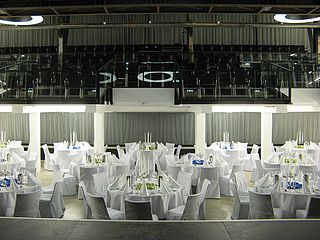Der Blick von der Bühne des großen Saals im Kulturwerk fällt auf weiß eingedeckte Tische und Ränge für weitere Gäste ©Mehrzwecksäle Norderstedt GmbH