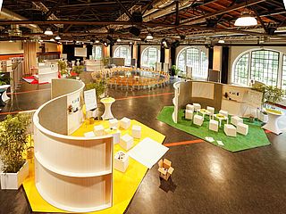 Die Raumaufteilung dieser Veranstaltung im Eventbereich der Lokhalle Mainz besteht aus einem großen Stuhlkreis und mehreren Stationen