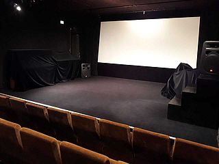 Blick aus den vorderen Reihen auf die Bühne des Kinosaals im Insitut français Bremen