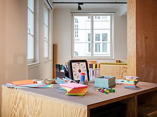 Auf dem Tisch der iD-Werkstatt der GfG Stuttgart sind verschiedene Materialien für die Visualisierung von Ideen ausgebreitet 