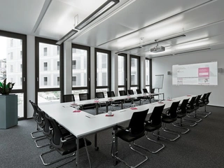 Der Raum des ecos office centers in Stuttgart verfügt über eine große Leinwand für Präsentationen während des Meetings