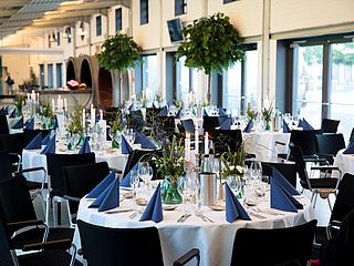 Mit typisch nordischer Dekoration aus Muscheln, wilden Blumen und blauen Servietten sind die Tische des Foyers im Kulturwerk Norderstedt wunderbar eingedeckt ©Mehrzwecksäle Norderstedt