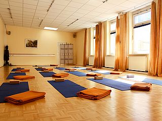 Ein sonnendurchfluteter Yoga- und Fitnessraum. 