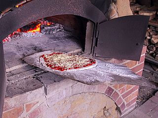 Schieb schieb in Ofen rein - Pizza auf dem Weg in den Feldbackofen des Gut Karlshöhe in Hamburg