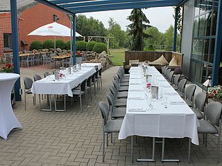 An den Tischen im Außenbereich der Partyscheune auf dem Bauernhof Lehmann in Celle finden zahlreiche Personen Platz
