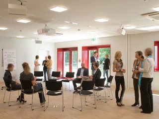 Gäste und ein Stuhlkreis im Tagungsraum R1 auf dem Gut Karlshöhe in Hamburg