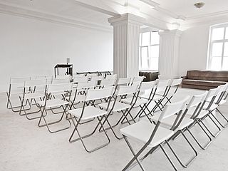 In mehreren Stuhlreihen finden in der FilmFabrique Hamburg viele Personen sitzend Platz