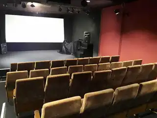 Blick aus den hinteren Reihen auf die Bühne des Kinosaals im Insitut français Bremen