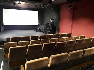 Blick aus den hinteren Reihen auf die Bühne des Kinosaals im Insitut français Bremen