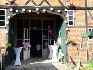 Der Eingang der denkmalgeschützten Fachwerkhalle der Diele am See im Herzogtum Lauenburg ist einladend gestaltet